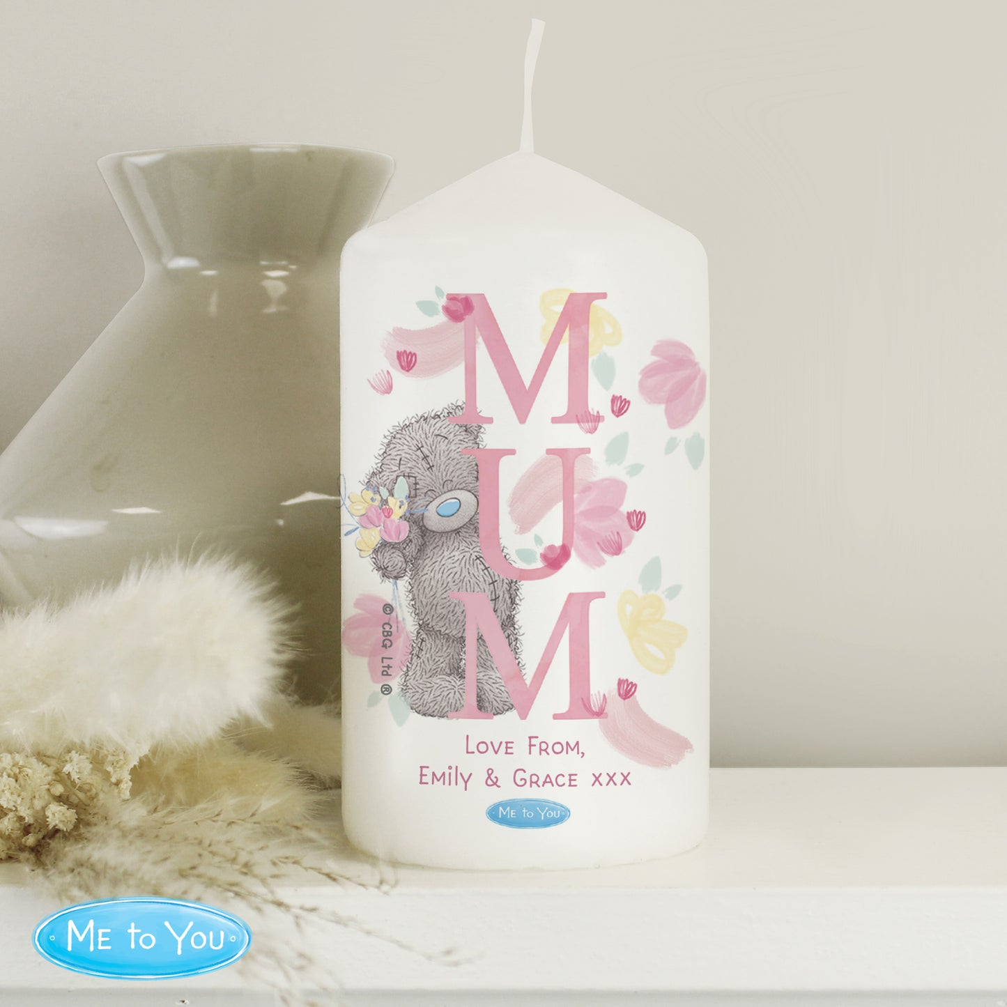 Candle with 'MUM' text and cartoon character, featuring 'Me to You' branding, on a neutral background.
