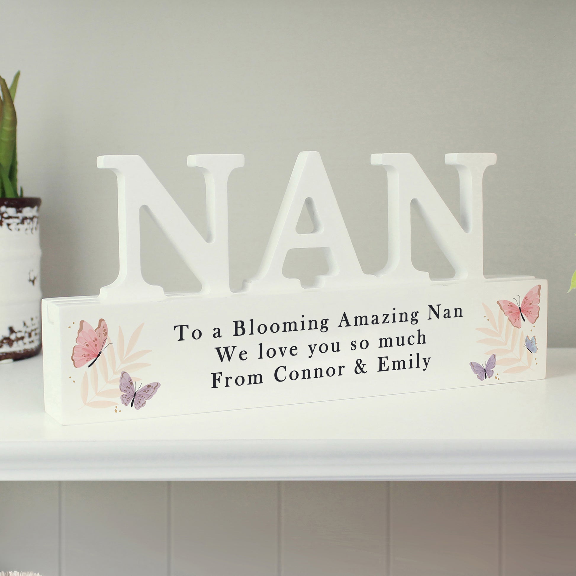 Decorative sign with 'NAN' and a message on a shelf.
