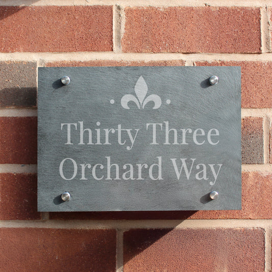 Slate house sign with 'Thirty Three Orchard Way' on a brick wall