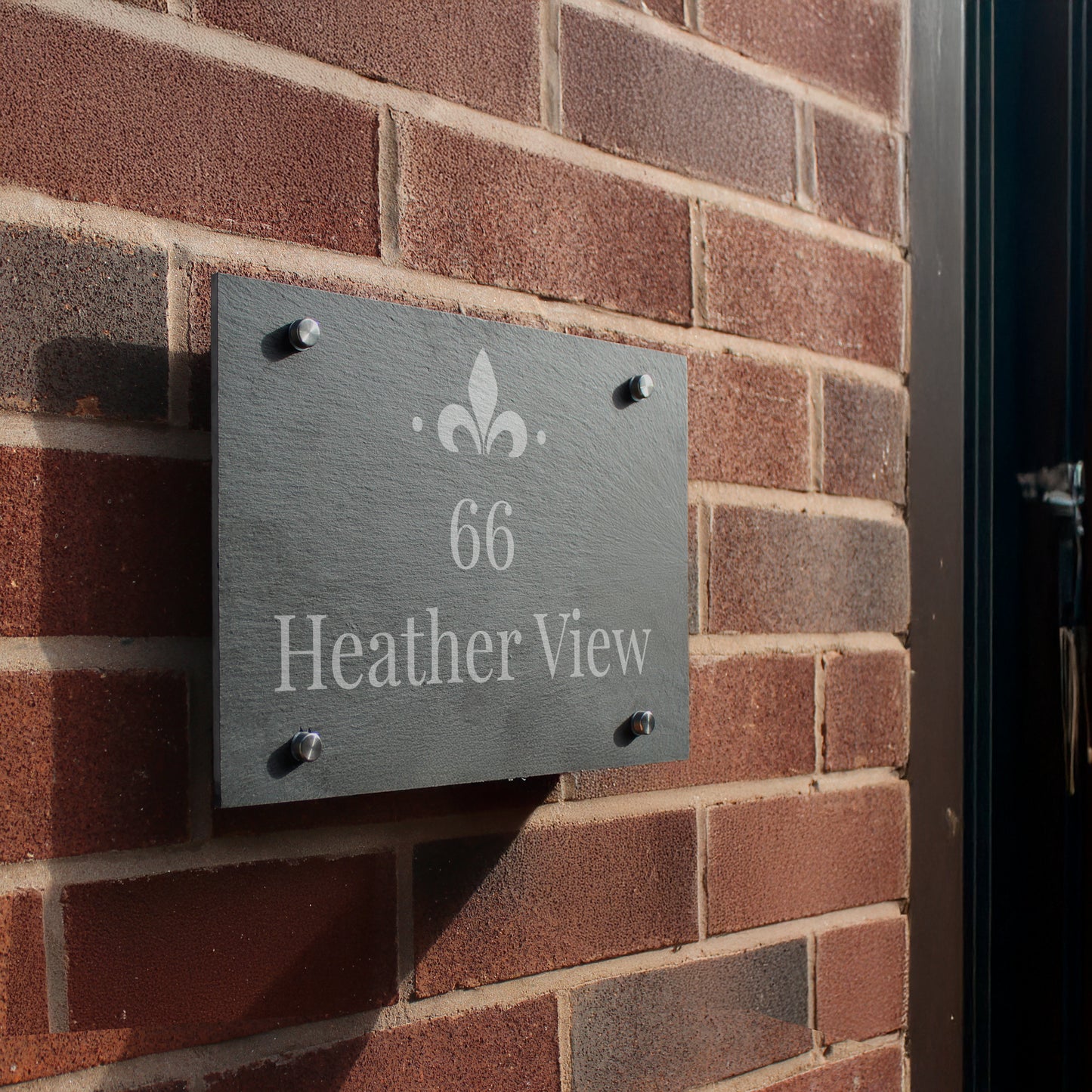 House number sign '66 Heather View' on a brick wall