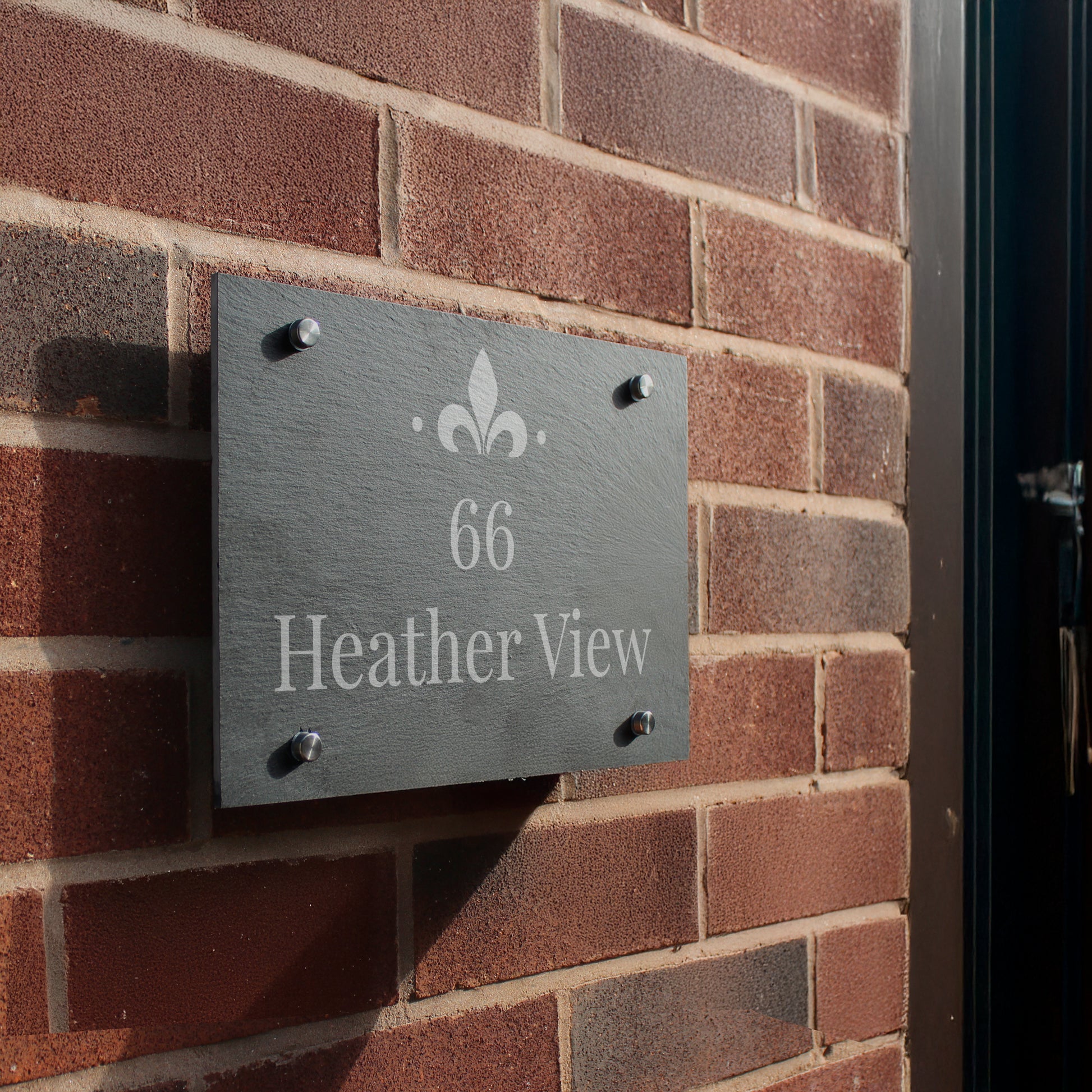 House number sign '66 Heather View' on a brick wall