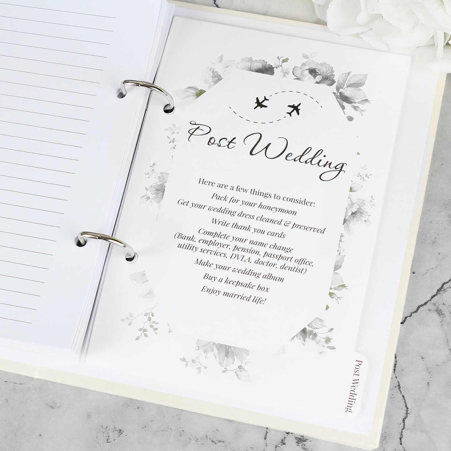 Open notebook with a post-wedding checklist on a marble surface