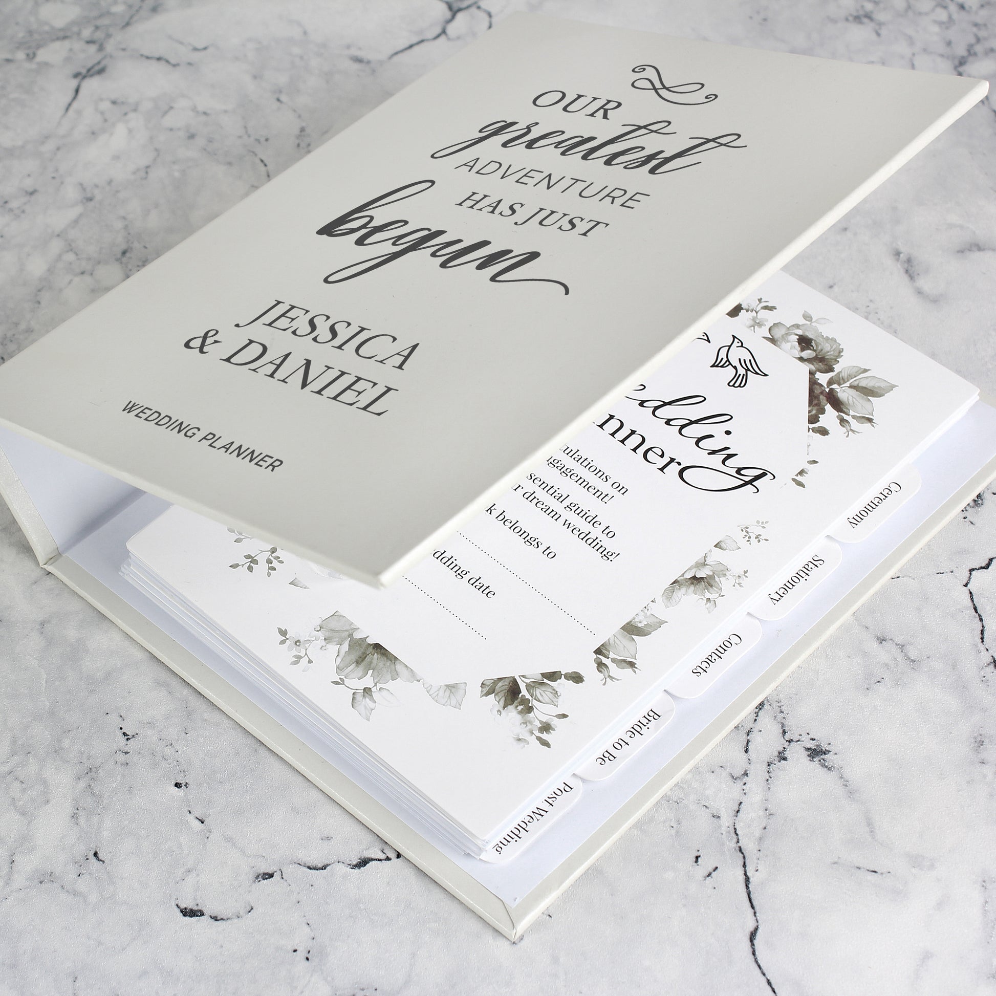 Wedding planner book with floral design on a marble surface