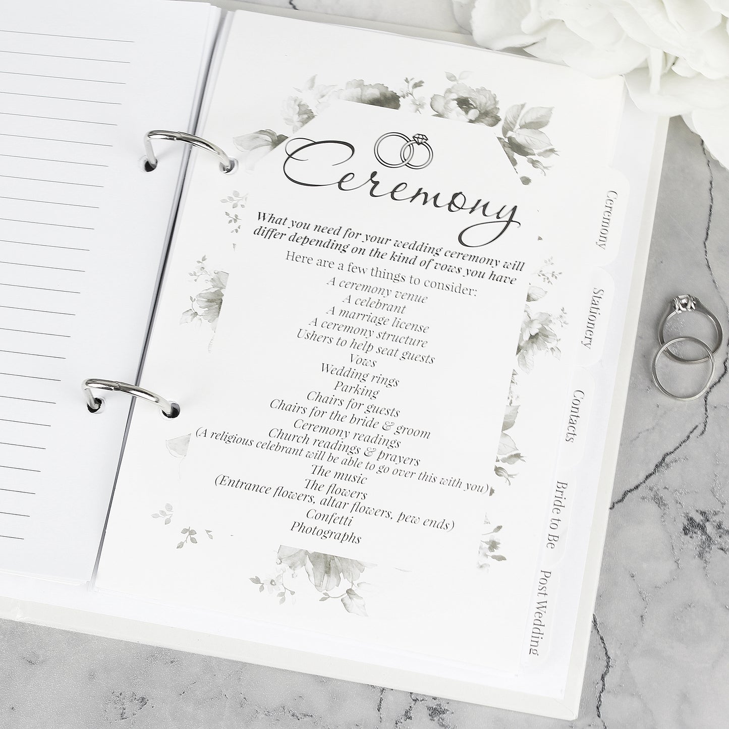 Wedding planner book with 'Ceremony' section on a marble surface