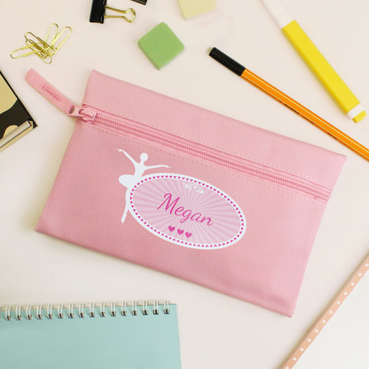 Pink pencil case with 'Megan' and a ballerina design on a desk with stationery items.