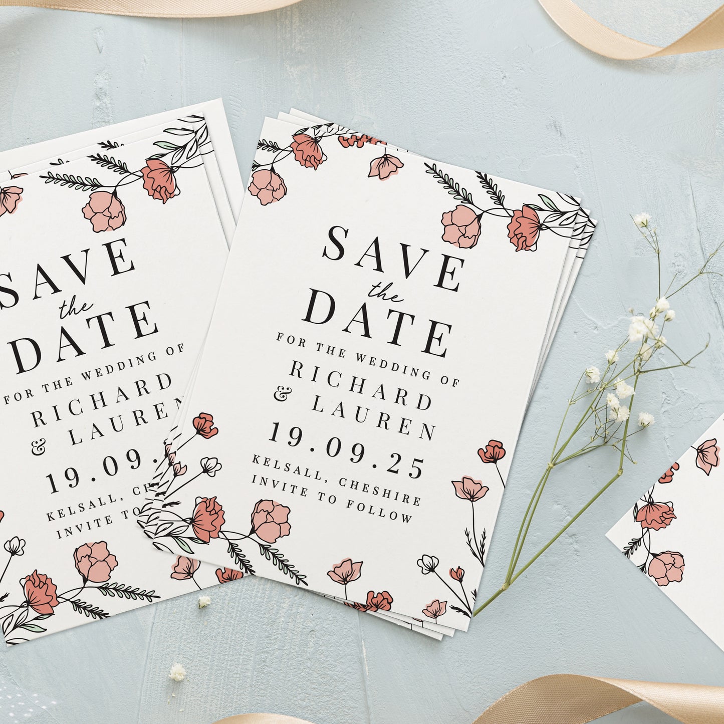 Save the date cards with floral design on a light blue surface