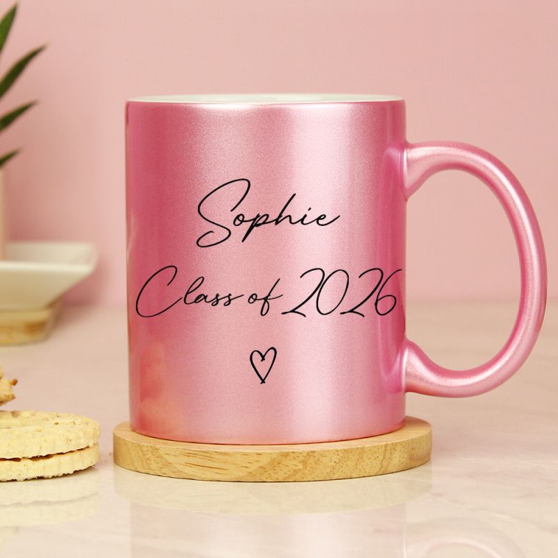 Pink glitter mug with personalised graduation details. Shown on a wooden coaster ( not included).