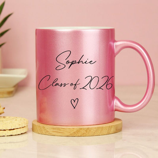 Pink glitter mug with personalised graduation details. Shown on a wooden coaster ( not included).