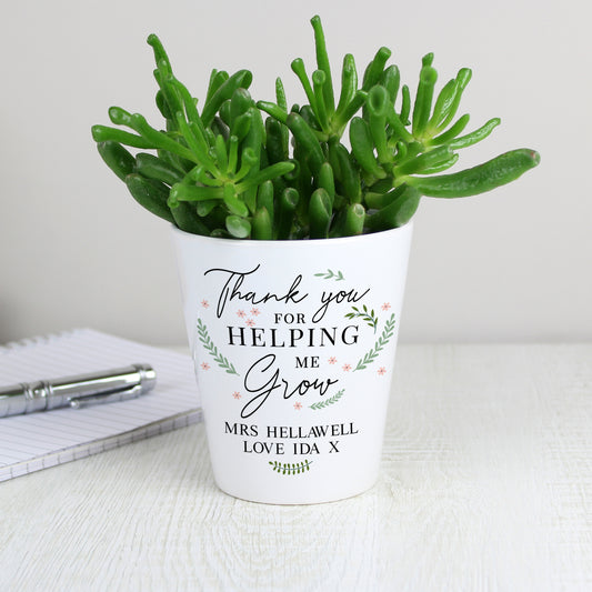 Potted succulent plant in a white pot with personalised text on a light surface.