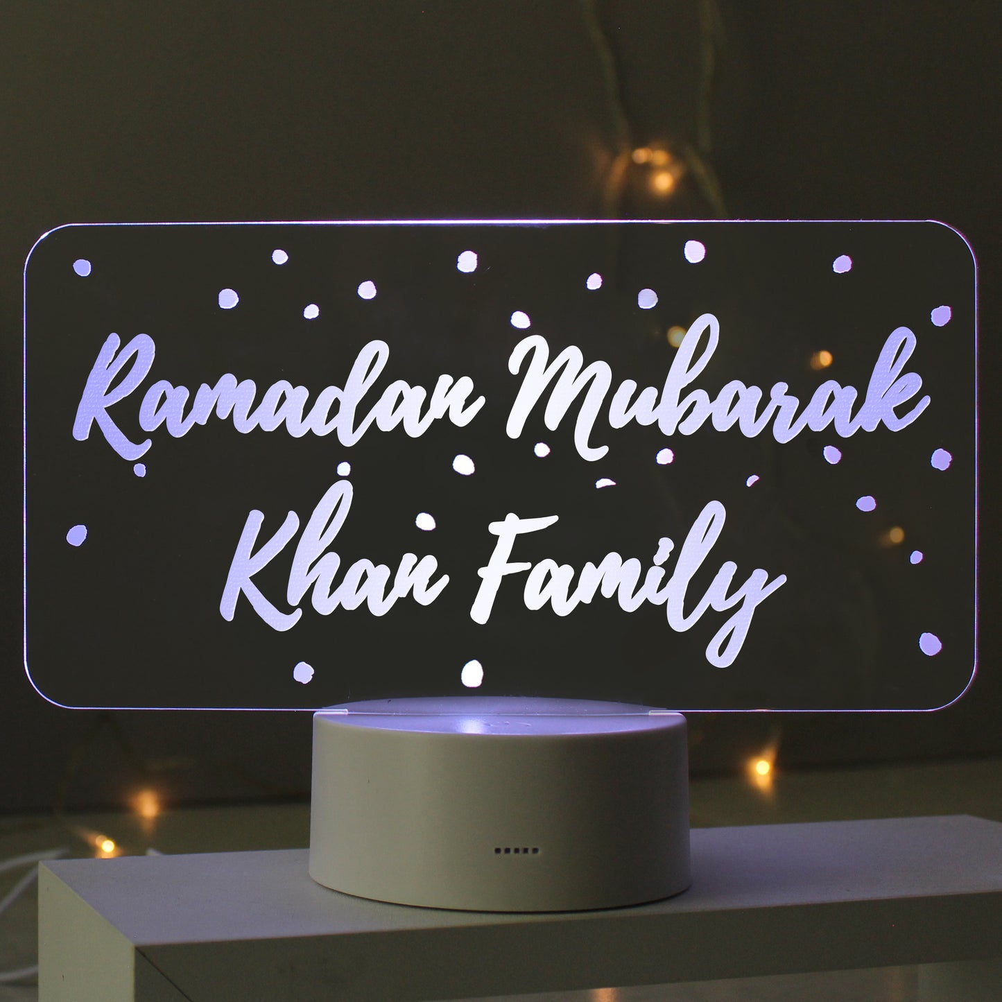 Decorative LED sign with 'Ramadan Mubarak Khan Family' text on a dark background.
