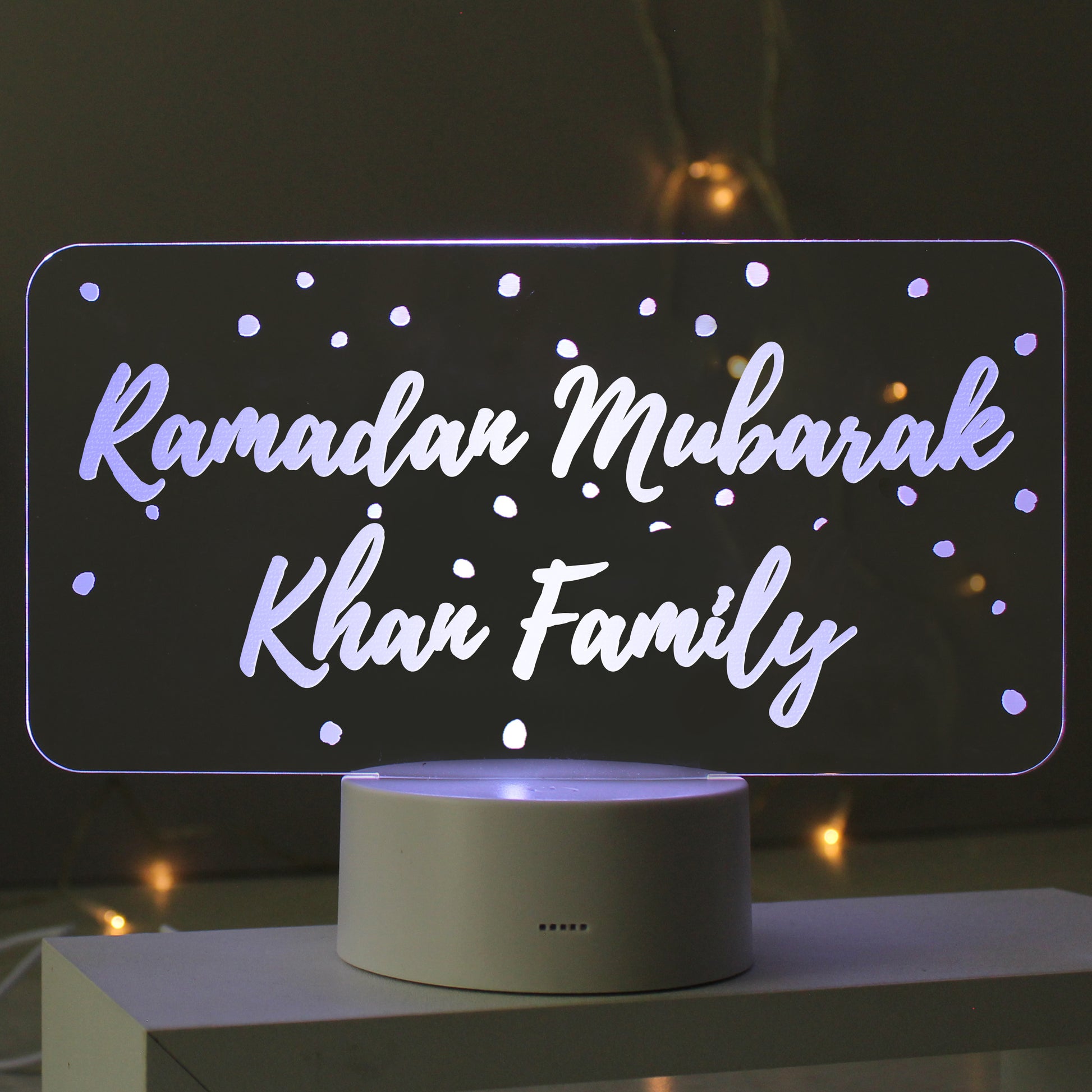 Decorative LED sign with 'Ramadan Mubarak Khan Family' text on a dark background.