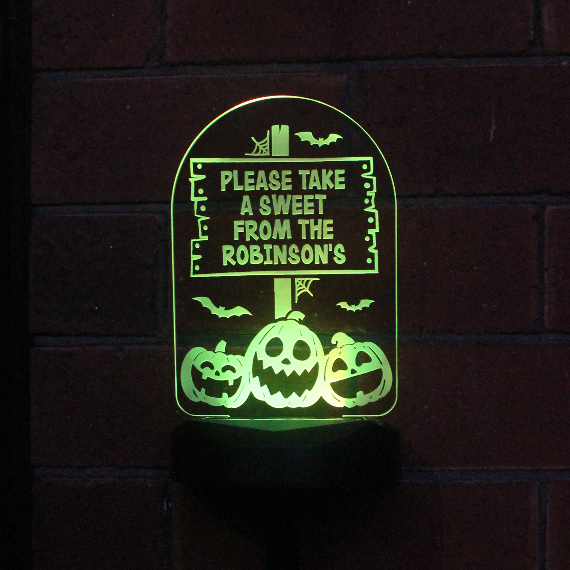 Solar Halloween light lit with green. Text reads Please take a  sweet from The Robinson's.