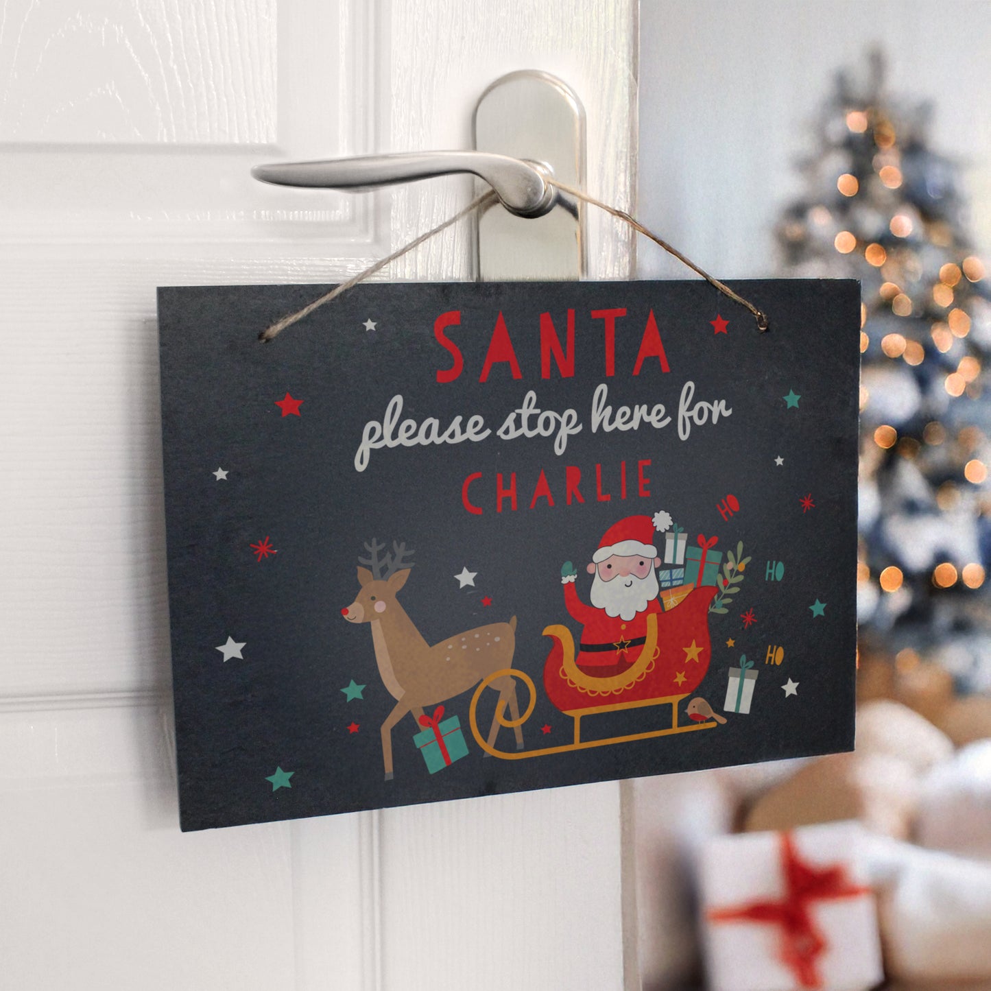 Slate sign with sleigh and Santa hanging on a door. Personalised text Santa please stop here for CHARLIE.