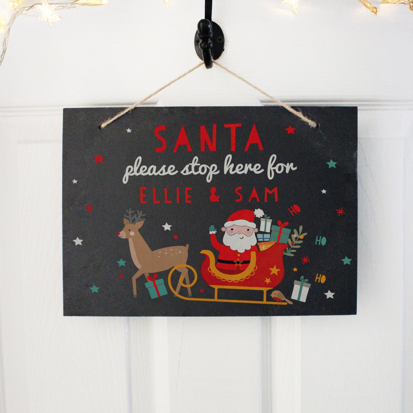 Slate Santa Stop Here sign shown on a front door.