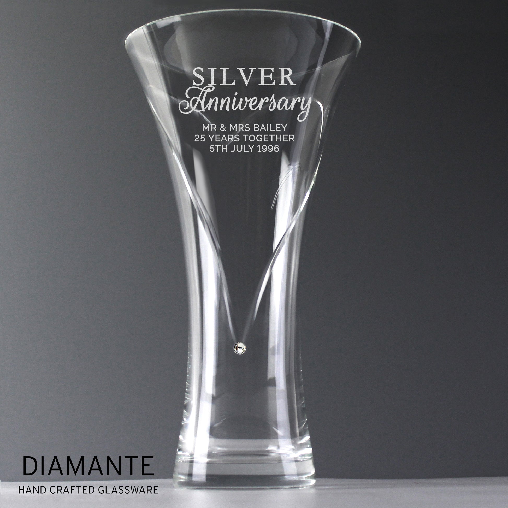 Clear glass vase with engraved 'Silver Anniversary' text on a dark background