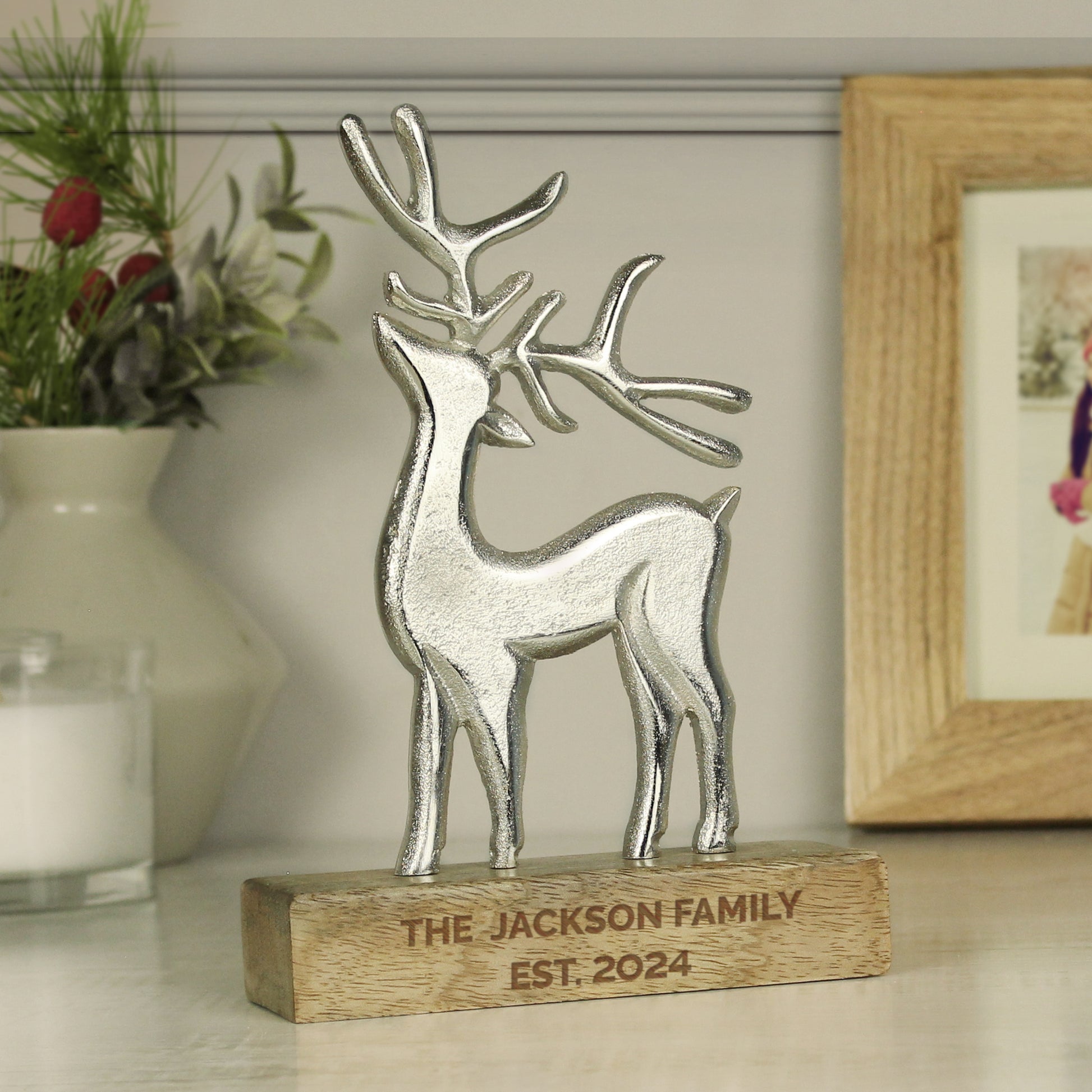 Decorative stag figurine on a wooden base with 'The Jackson Family Est. 2024' engraving, placed on a surface with a blurred background.