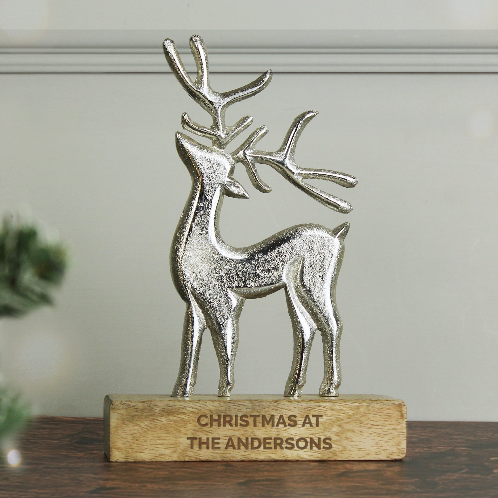Decorative silver deer figurine on a wooden base with 'Christmas at The Andersons' engraving.
