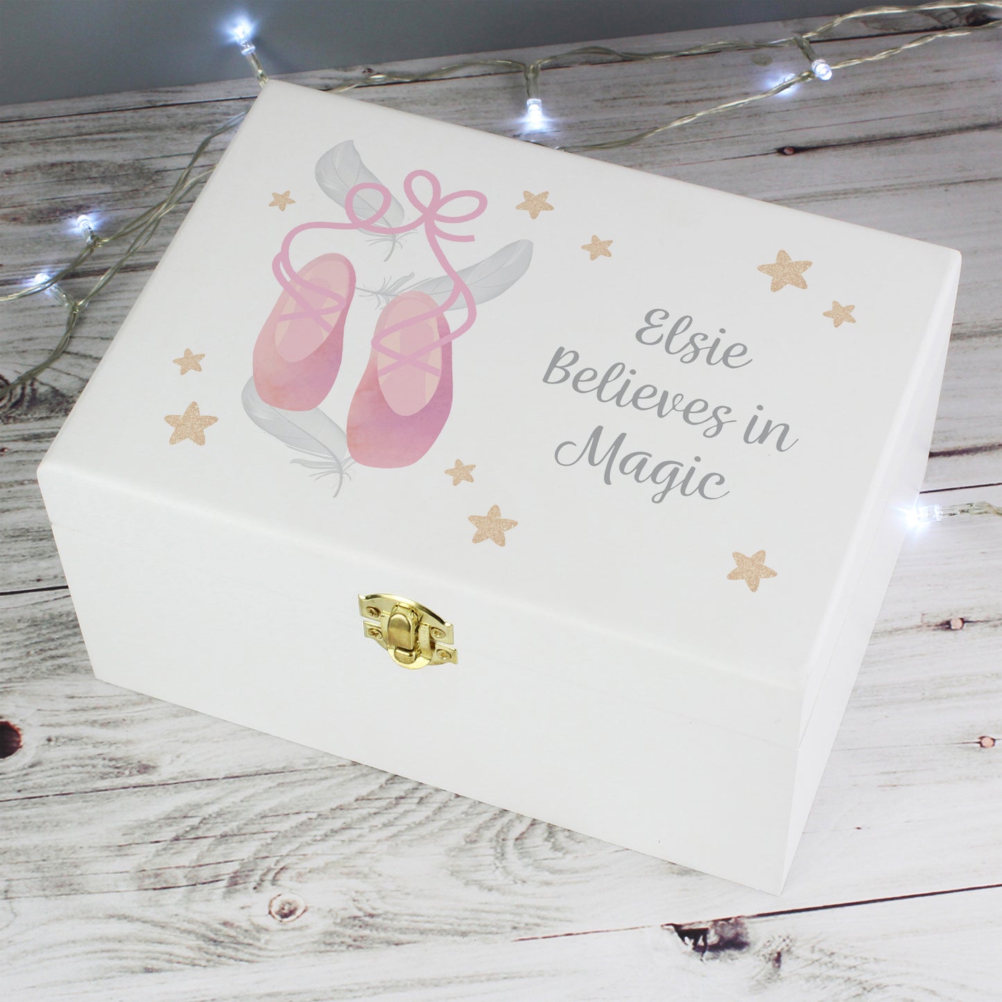 White jewelry box with pink ballet shoes and 'Elsie Believes in Magic' text on a wooden surface.