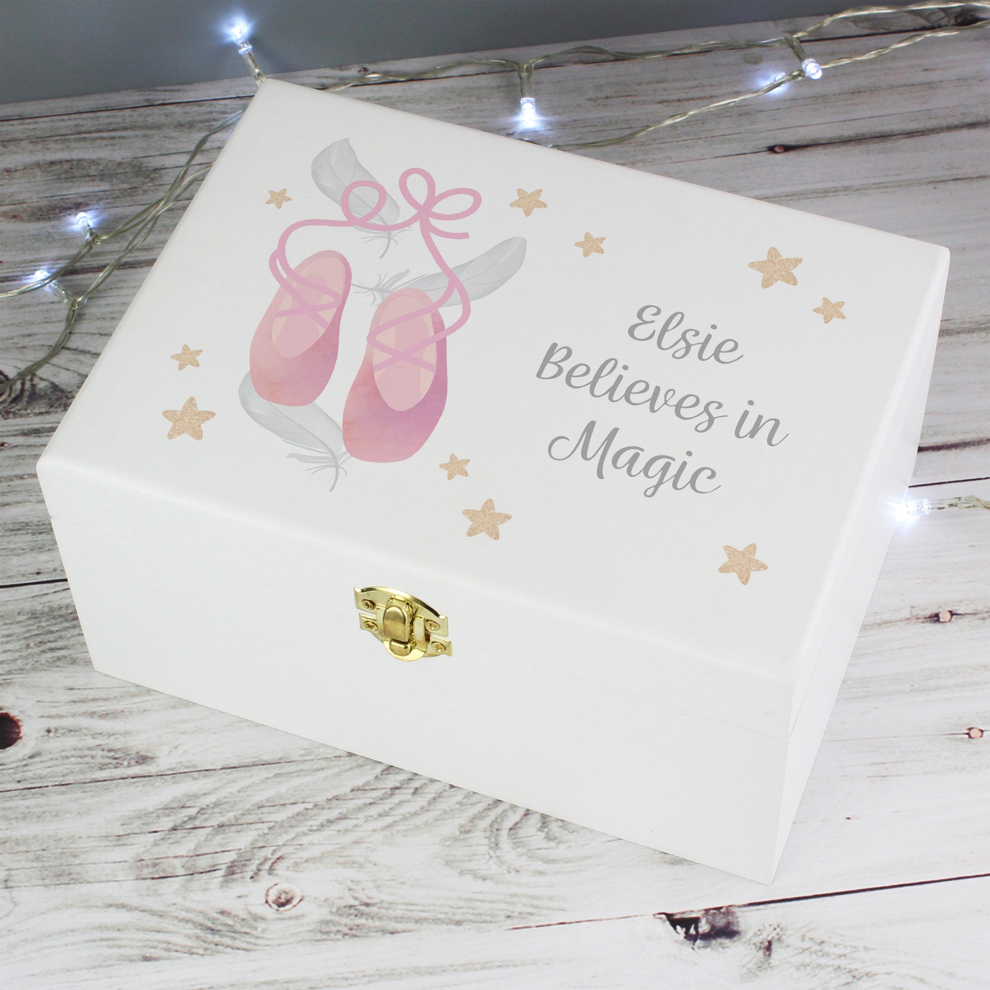 White jewelry box with pink ballet shoes and 'Elsie Believes in Magic' text on a wooden surface.
