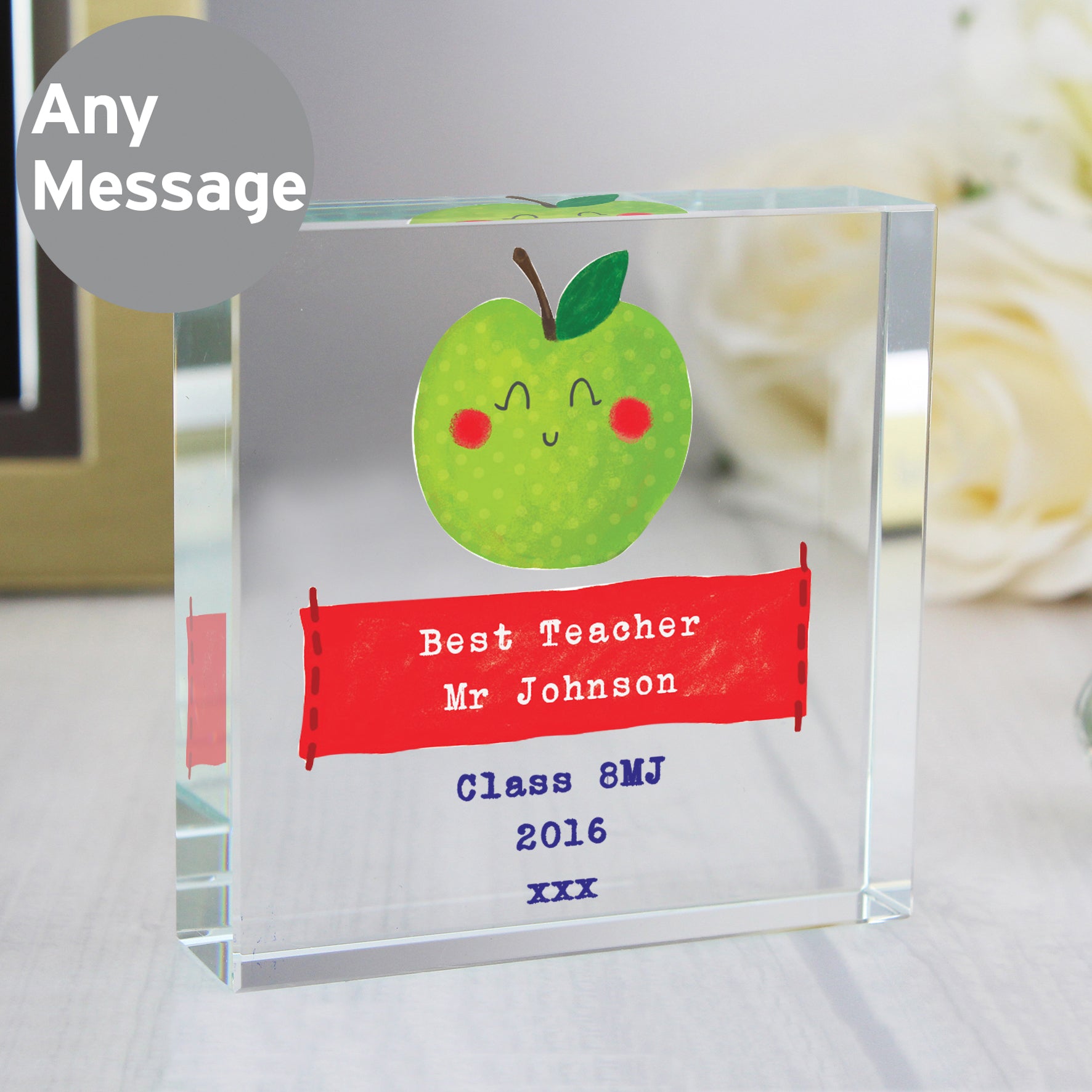 Personalised glass award with a cartoon apple and customisable text on a blurred background.