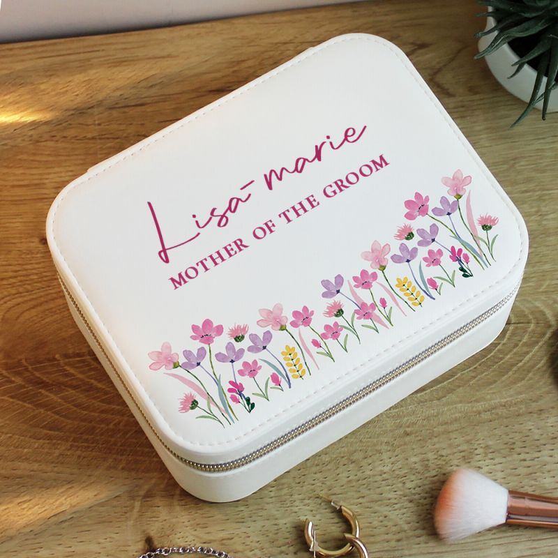White jewelry case with floral design and text on a wooden surface