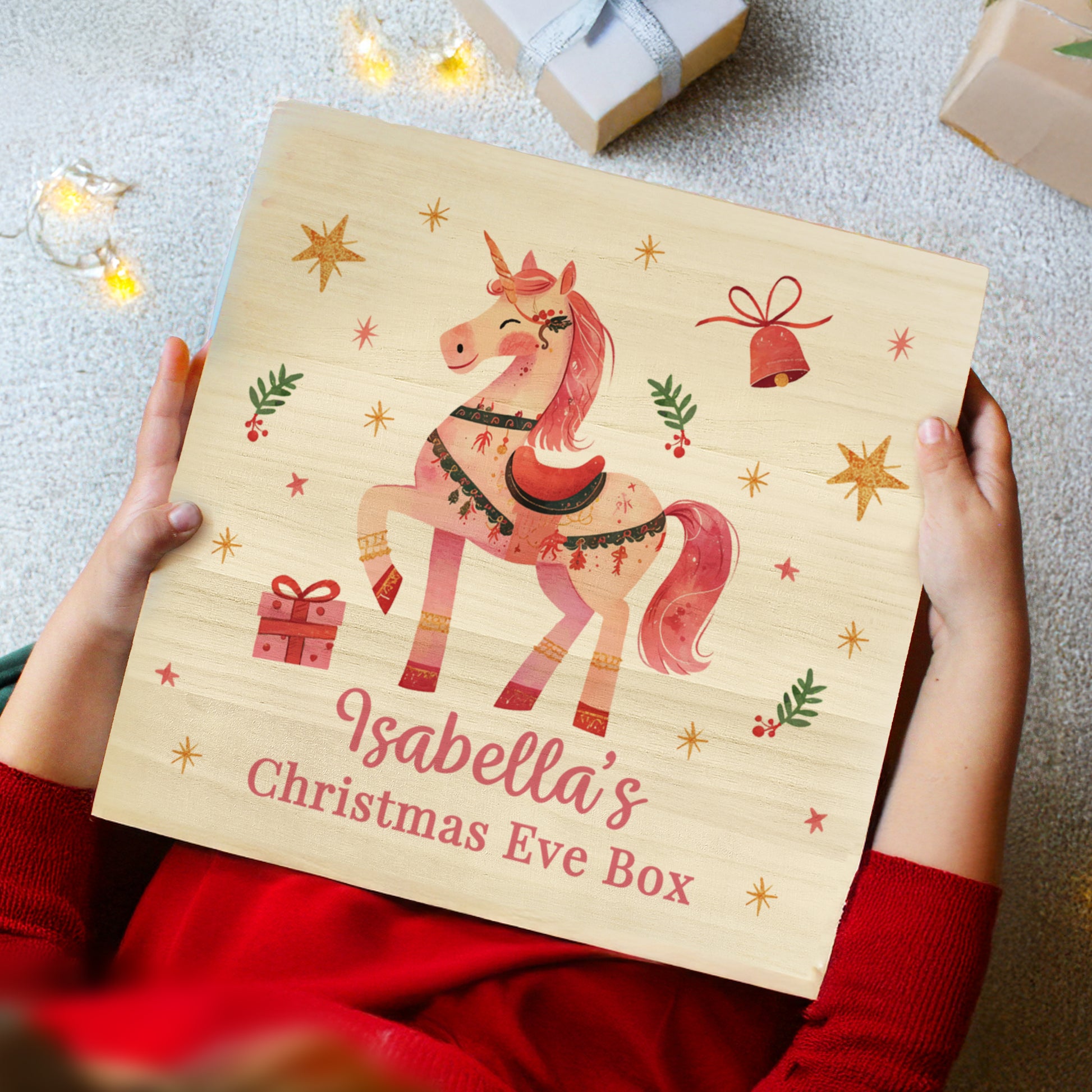 Child's hands holding wooden Christmas Eve box. Personalised with Isabellla's Christmas Eve Box.