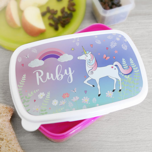 Lunch box with unicorn design and 'Ruby' on a table with snacks