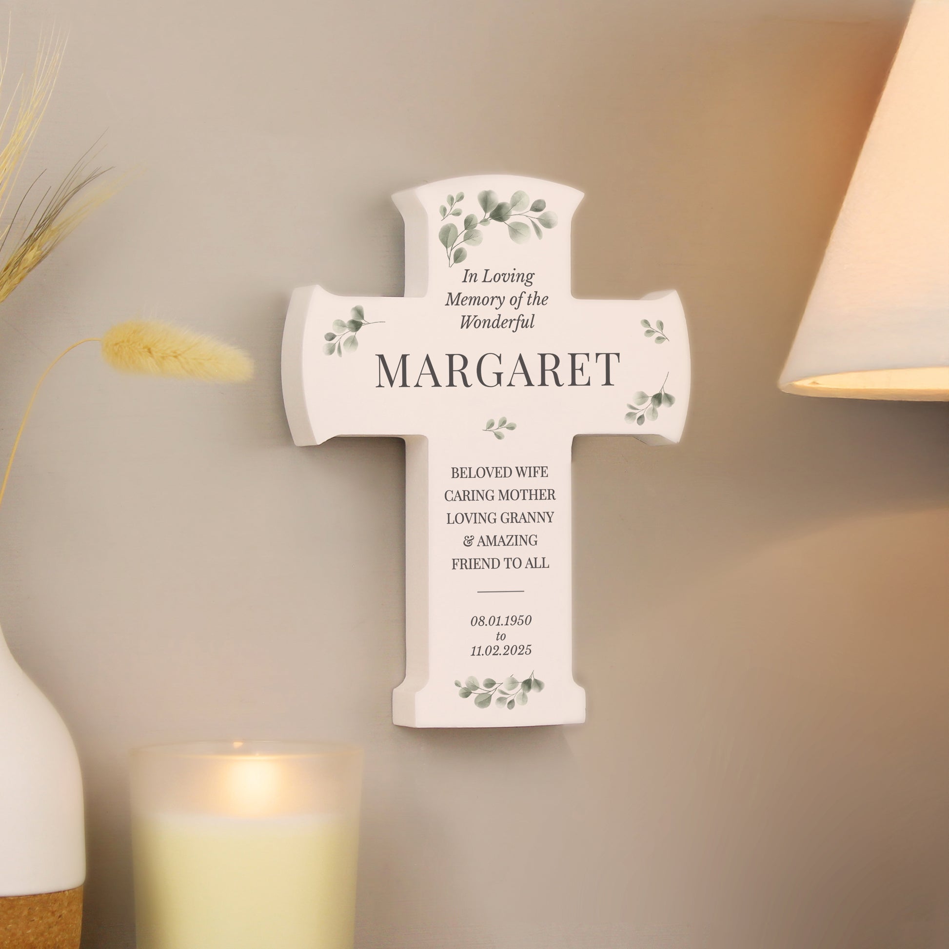 Memorial cross for Margaret on a wall with decorative elements.