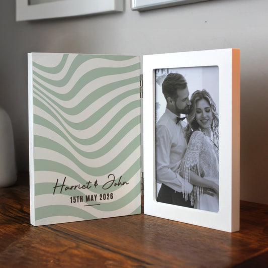 Personalised photo book with wavy design and couple's photo on wooden surface