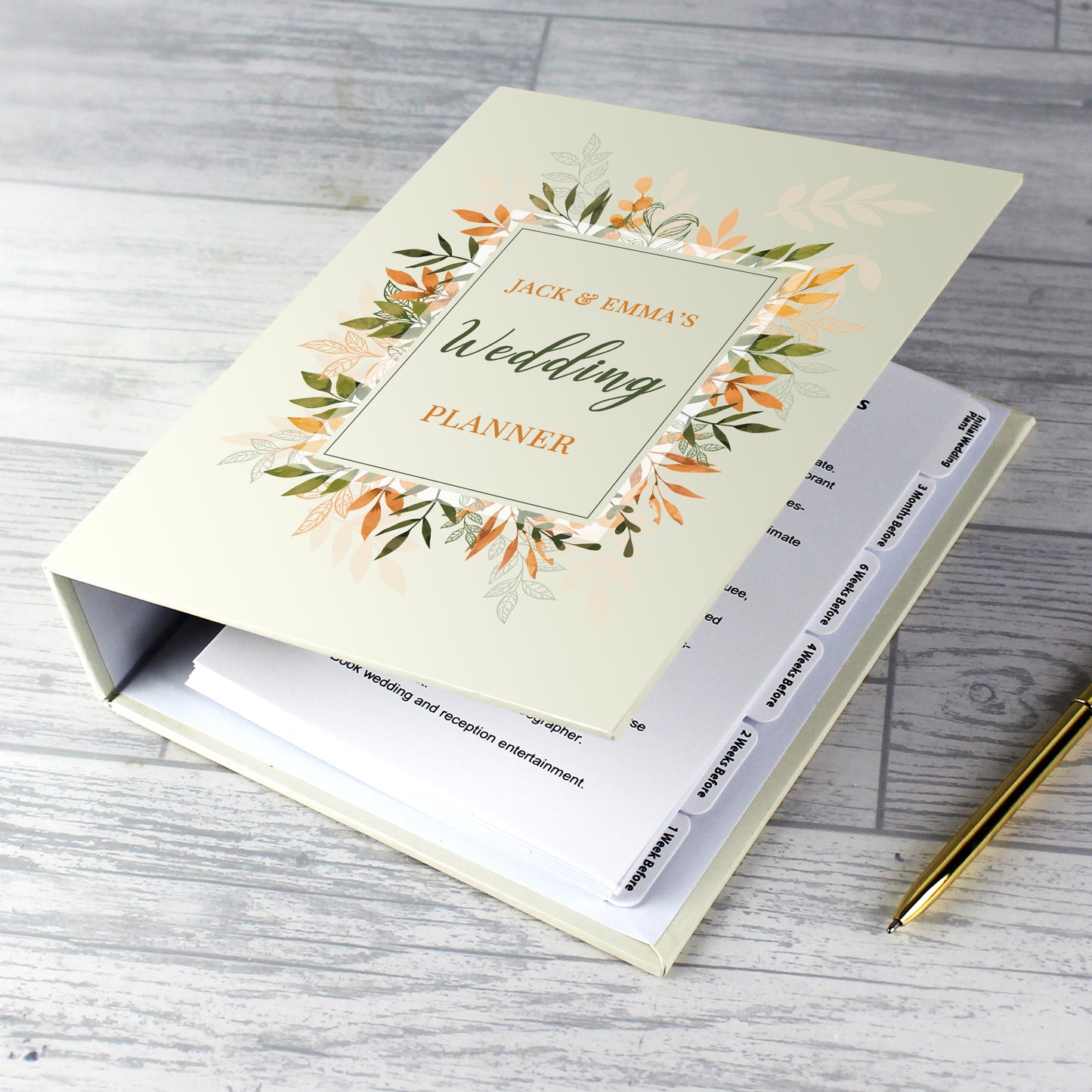 Wedding planner book with floral design on a wooden surface