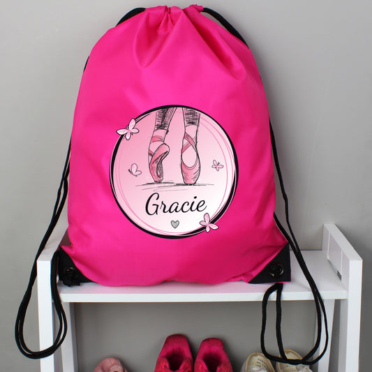 Pink drawstring bag with ballet-themed design and 'Gracie' text on a white shelf.