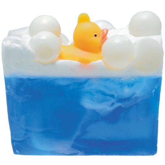 Pool Party soap slice from Bomb Cosmetics with lavender essential oils. Blue lower layer topped with white foam and bubbles. Topped with a bright yellow duck! Glycerin soap and vegan friendly.