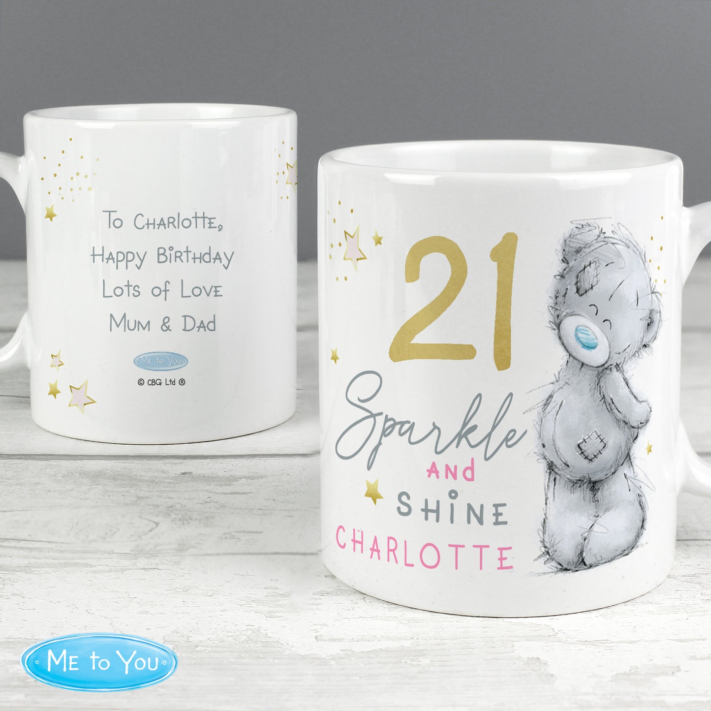 Back and front of personalised mugs with text and a bear illustration on a wooden surface.