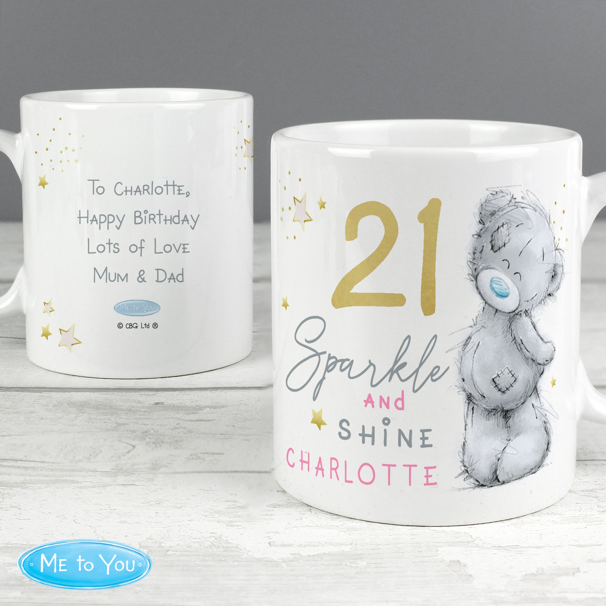 Back and front of personalised mugs with text and a bear illustration on a wooden surface.