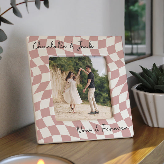 Checkered photo frame with a couple's photo and 'Charlotte & Jack' text on a wooden surface.