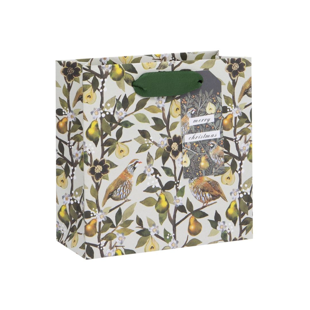 Off white gift bag with partridges in a pear tree with green ribbon handles and matching gift tag