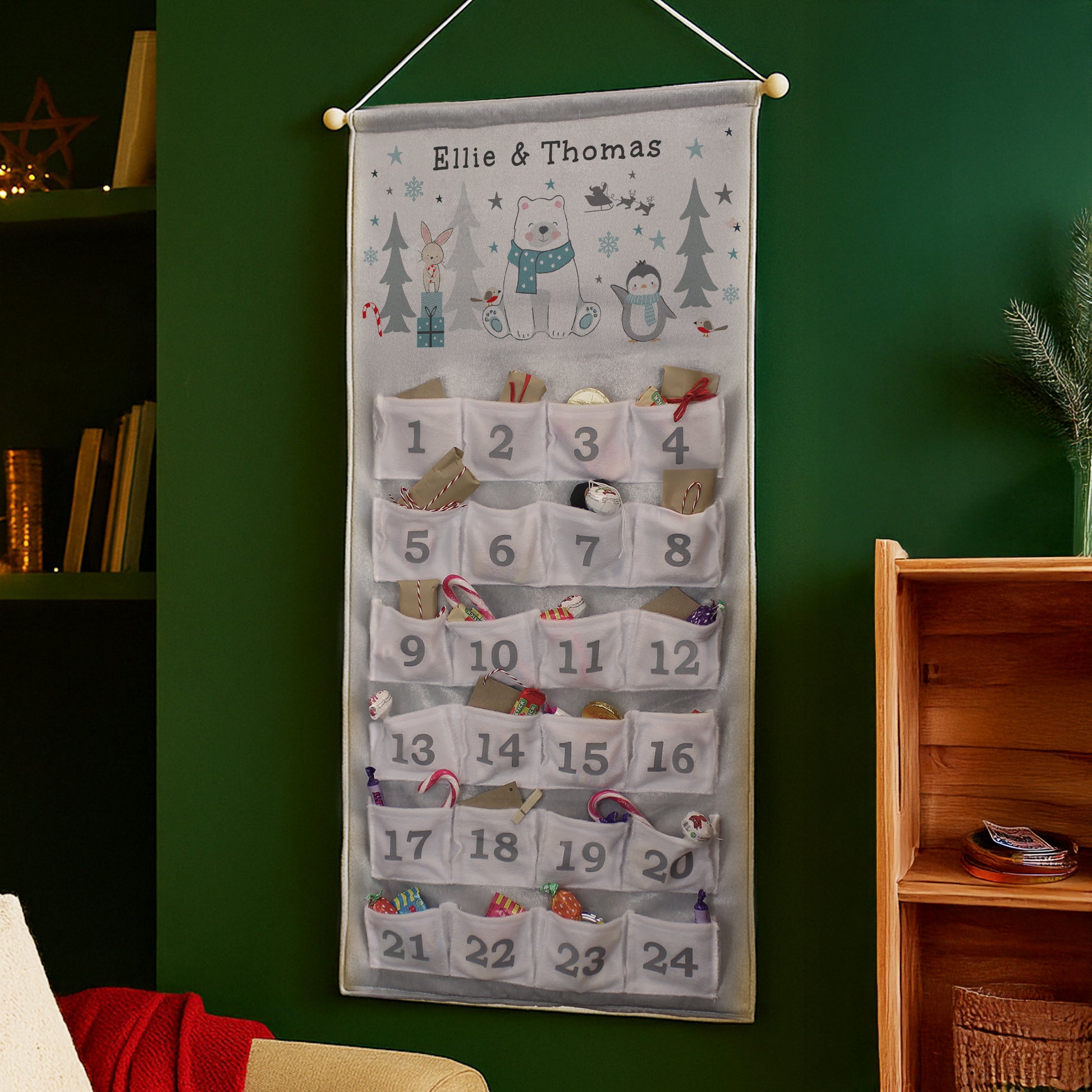 Hanging Advent calendar with cartoon characters on a green wall