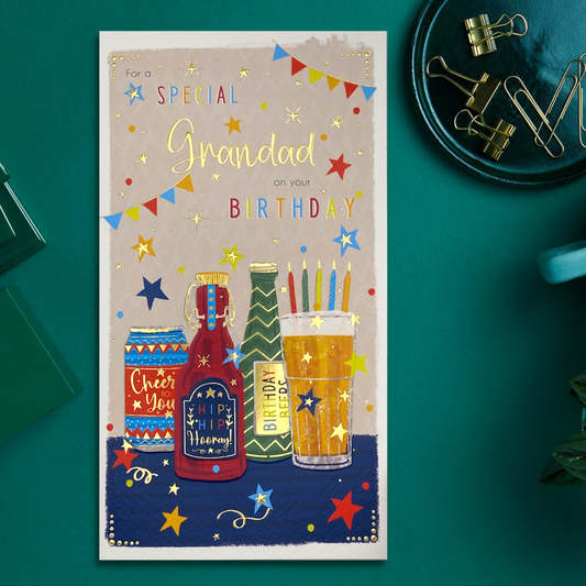 Front image of grandad birthday card showing brightly coloured beers and candles with bunting and gold foil details