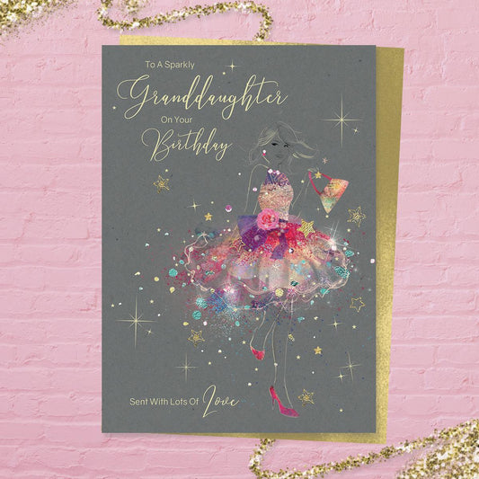 To A Very Special Granddaughter On Your Birthday Sent With Lots Of Love' card from the 'Grace' range. Beautiful Girl In Multi Colour Dress With Added Sparkle And Gold Foil Detail. Printed Insert with Colour Image Inside And Heartfelt Verse. Complete With Gold Colour Envelope. So Pretty!