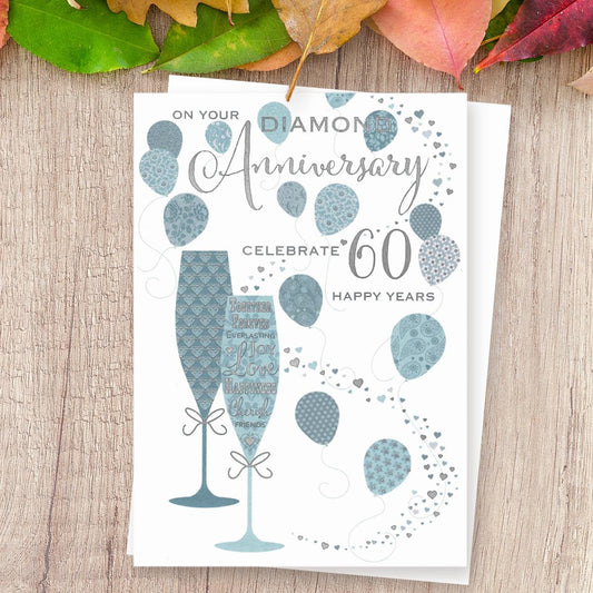 On Your Diamond Anniversary Celebrate 60 Happy Years' Card Featuring Two Flutes With Balloons. With Beautiful Silver Foil Detail And White Envelope